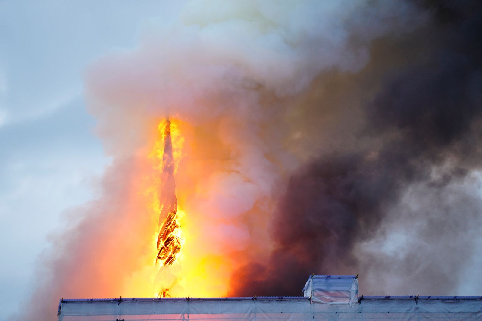 Detall de l'agulla de la torre, envoltada per les flames