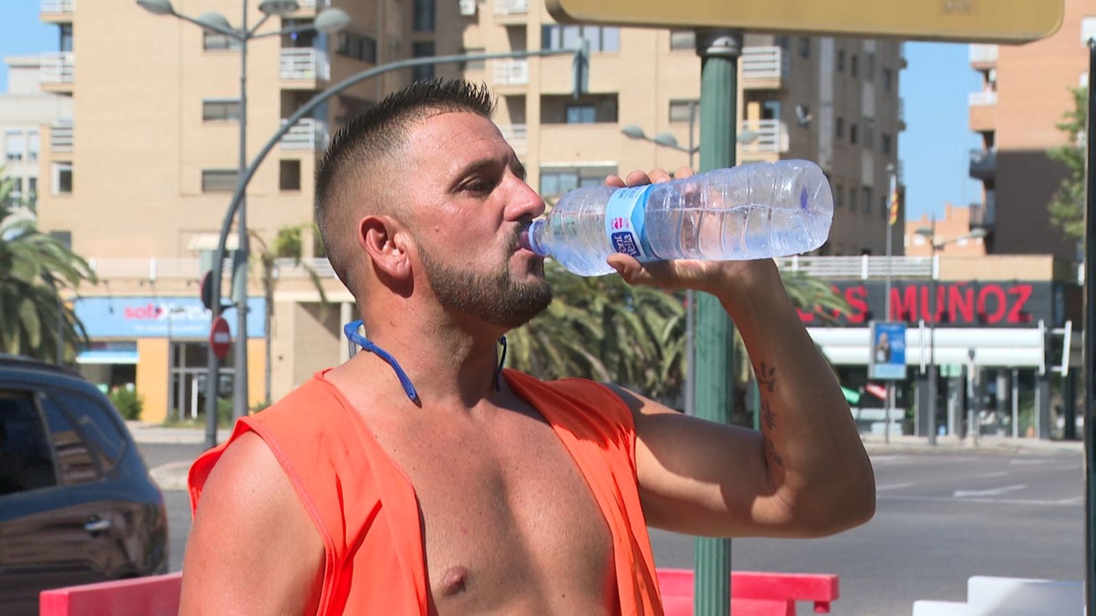Un treballador de l'obra s'hidrata durant l'onada de calor