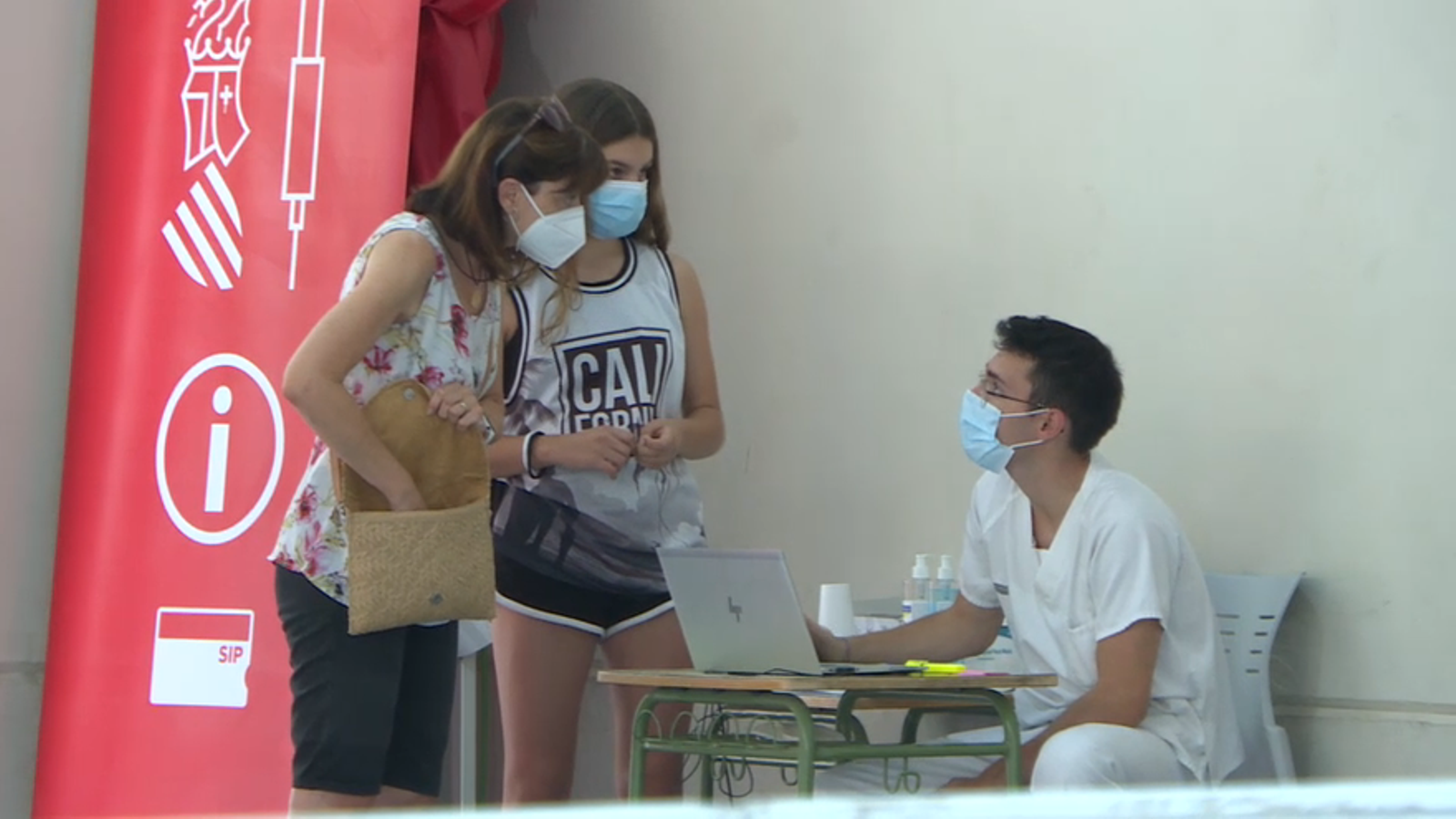 Una menor amb sa mare en un punt de vacunació