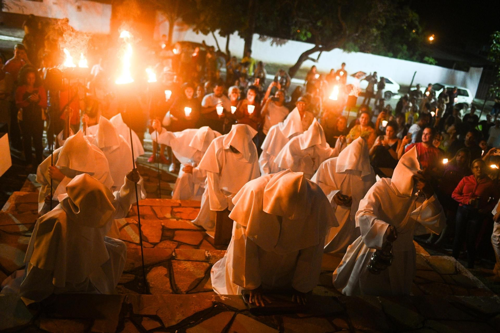Fidels catòlics participen en la processó dels Penitents aquest Dijous Sant. També coneguda com la processó de les Ànimes, recorre els carrers del centre històric fins al cementeri portant torxes i veles en oració per les ànimes dels qui es troben en el purgatori (6 d'abril de 2023)