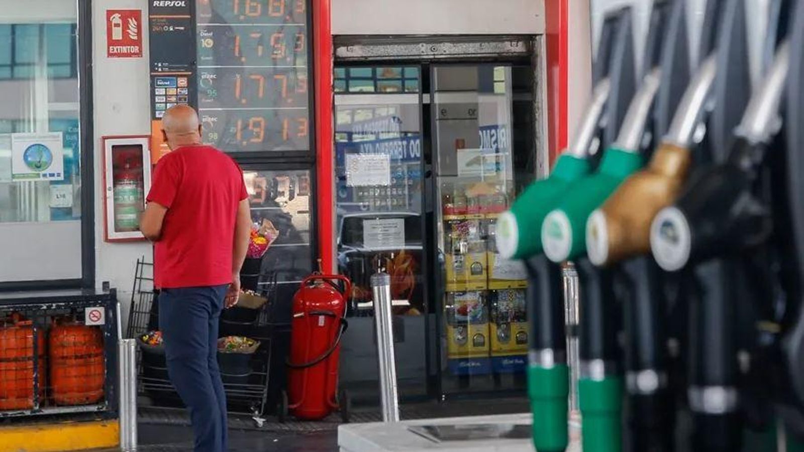 Un home mira els preus dels combustibles en una estació de servei