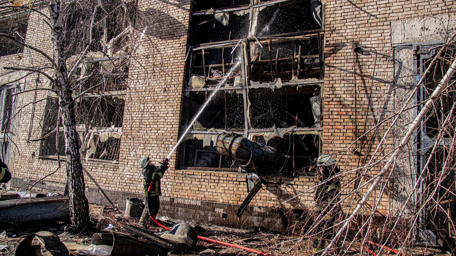 Un bomber apaga un incendi en un edifici bombardejat a Kíiv