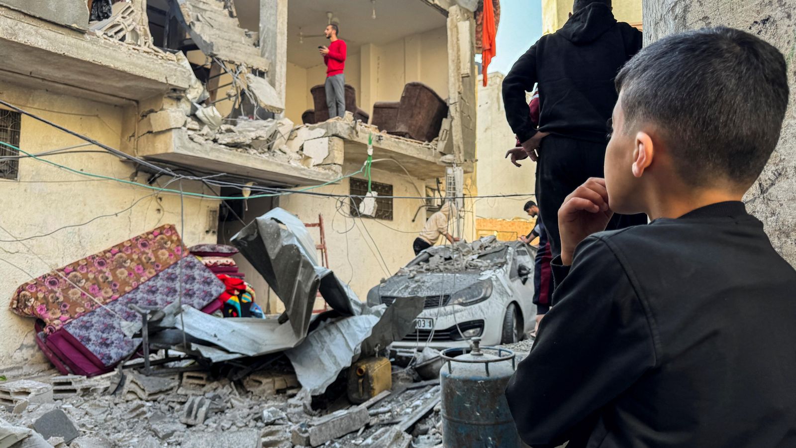 Civils palestins contemplen les runes d'una casa a la ciutat de Khan Yunis