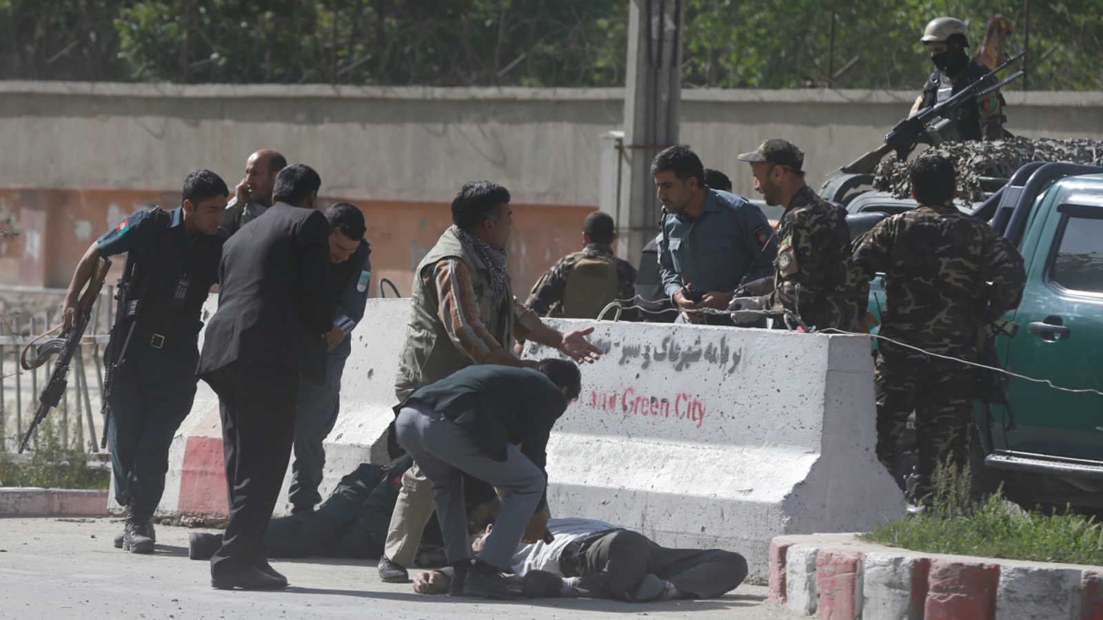 Alguns policies ajuden els periodistes ferits que han sobreviscut a l'atemptat suïcida dirigit contra la premsa al centre de Kabul