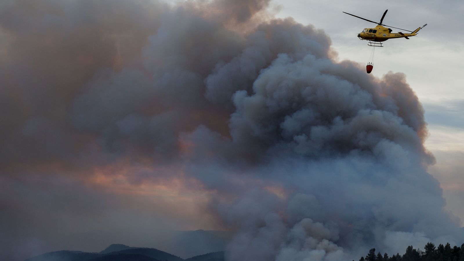 Un dels helicòpters que participava en les tasques d'extinció de l'incendi forestal a primera hora d'aquest divendres
