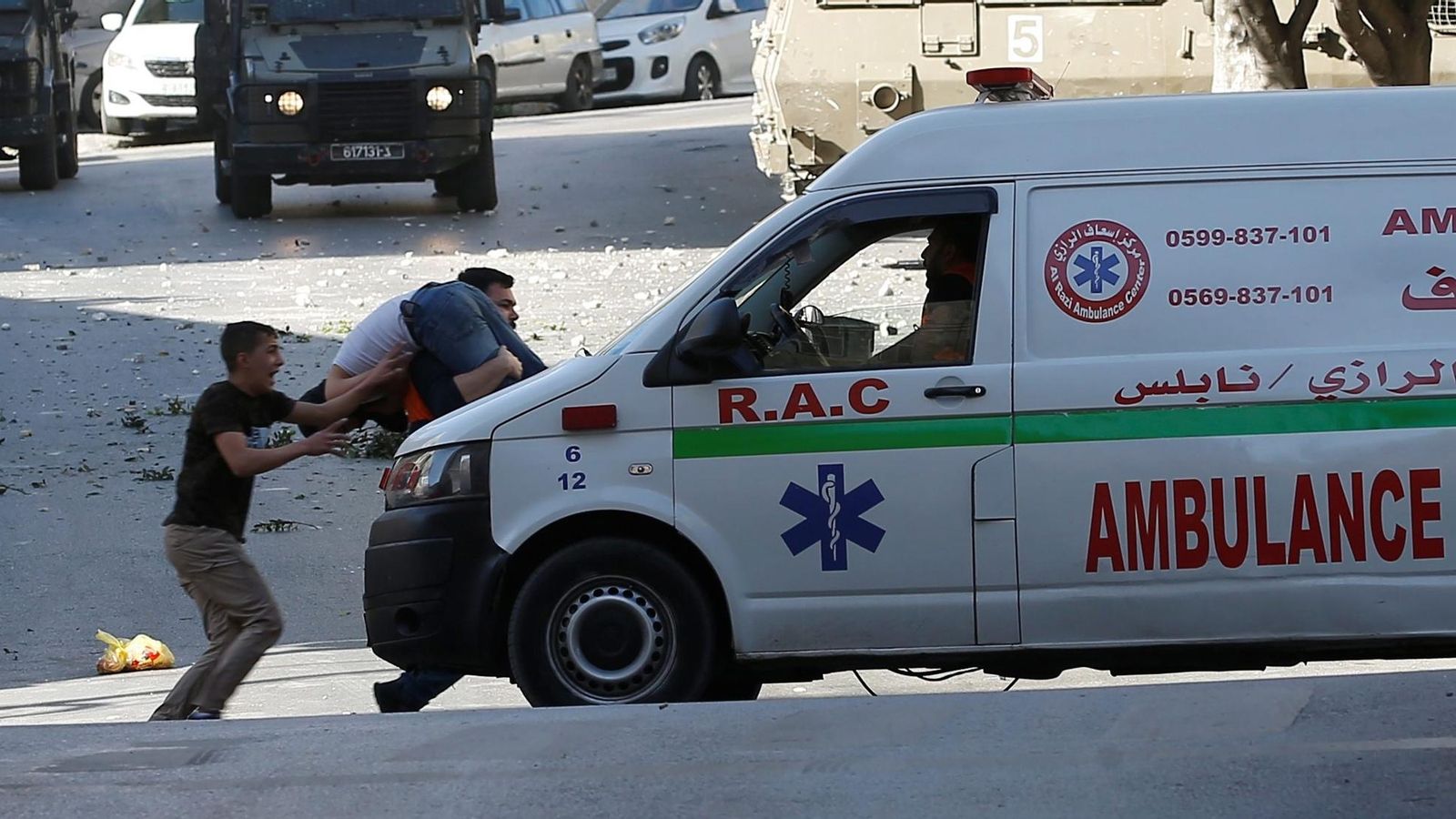 Un home evacua una persona palestina ferida durant la incursió a Nablus