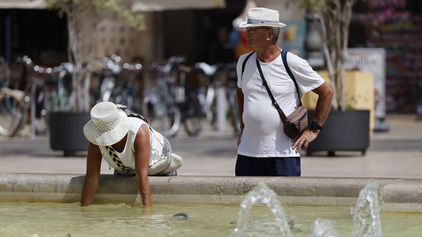 Una dona es refresca en una font