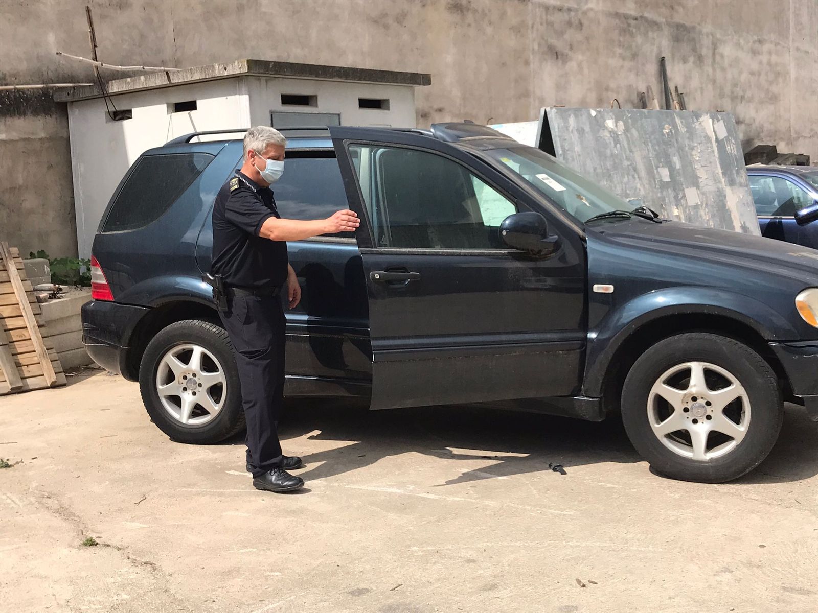 Un agent de la Policia Local mostra el cotxe on hi havia els bitllets falsos al depòsit municipal de vehicles de Pego