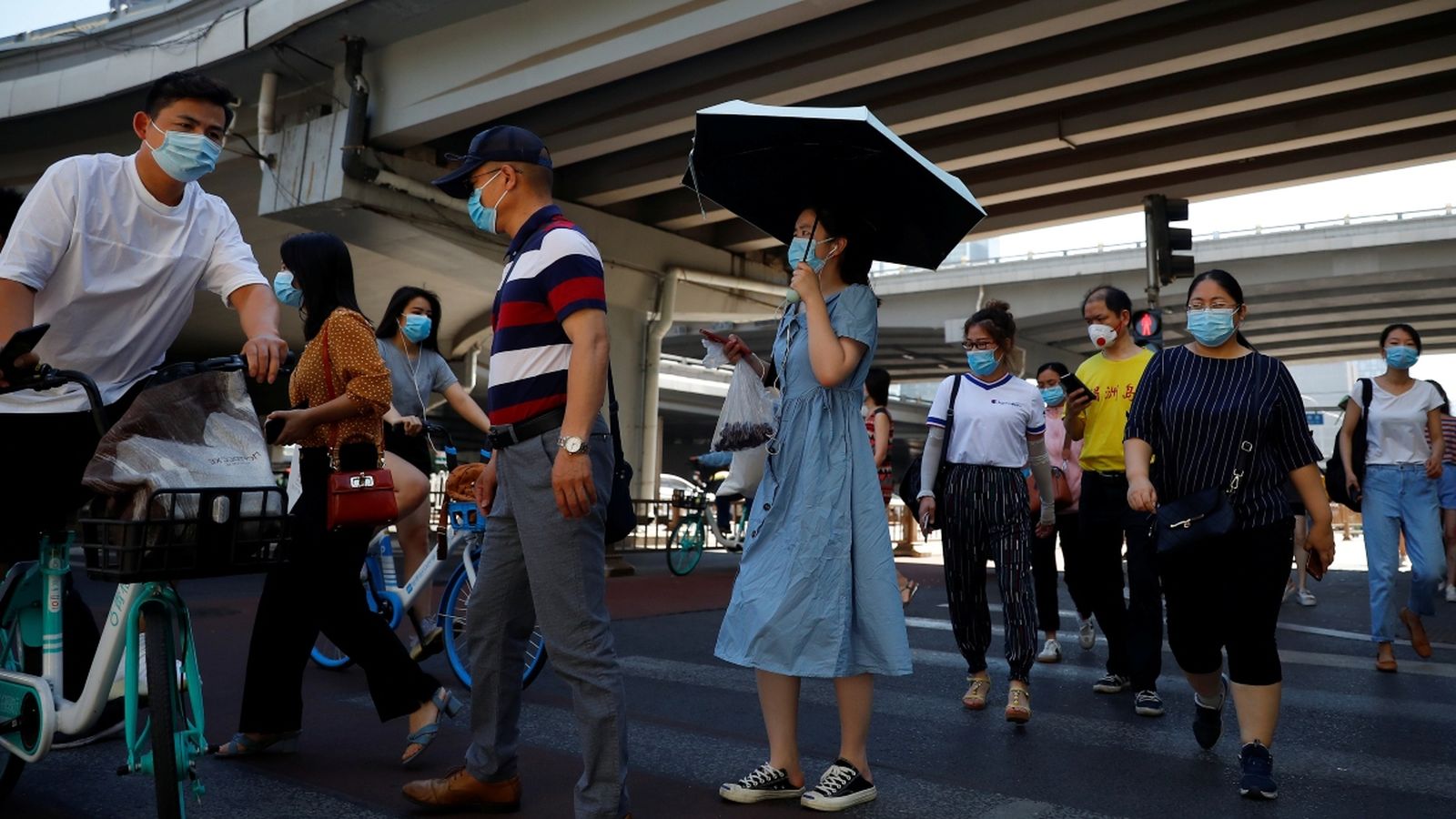 Diverses persones protegides amb mascareta es dirigeixen a treballar a Pequín (Reuters)