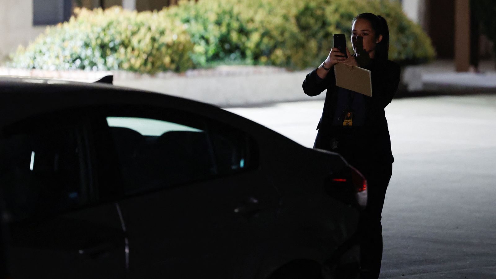 Una investigadora fa fotos a un vehicle aparcat en les immediacions de l'església on ha tingut lloc el tiroteig