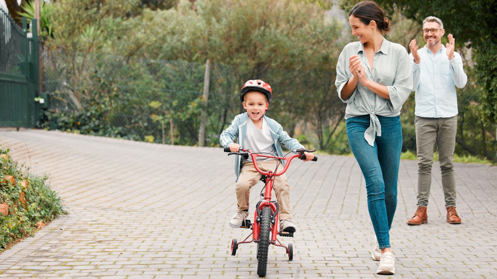 Una família amb el seu fill aprenent a muntar en bicicleta