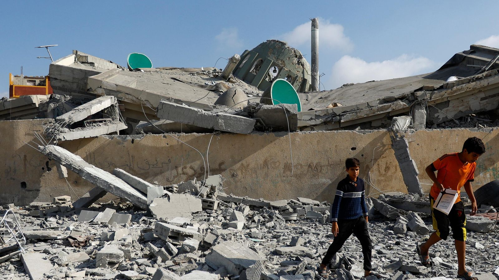 Niños palestinos caminan en el lugar de un ataque israelí contra una mezquita en Khan Younis