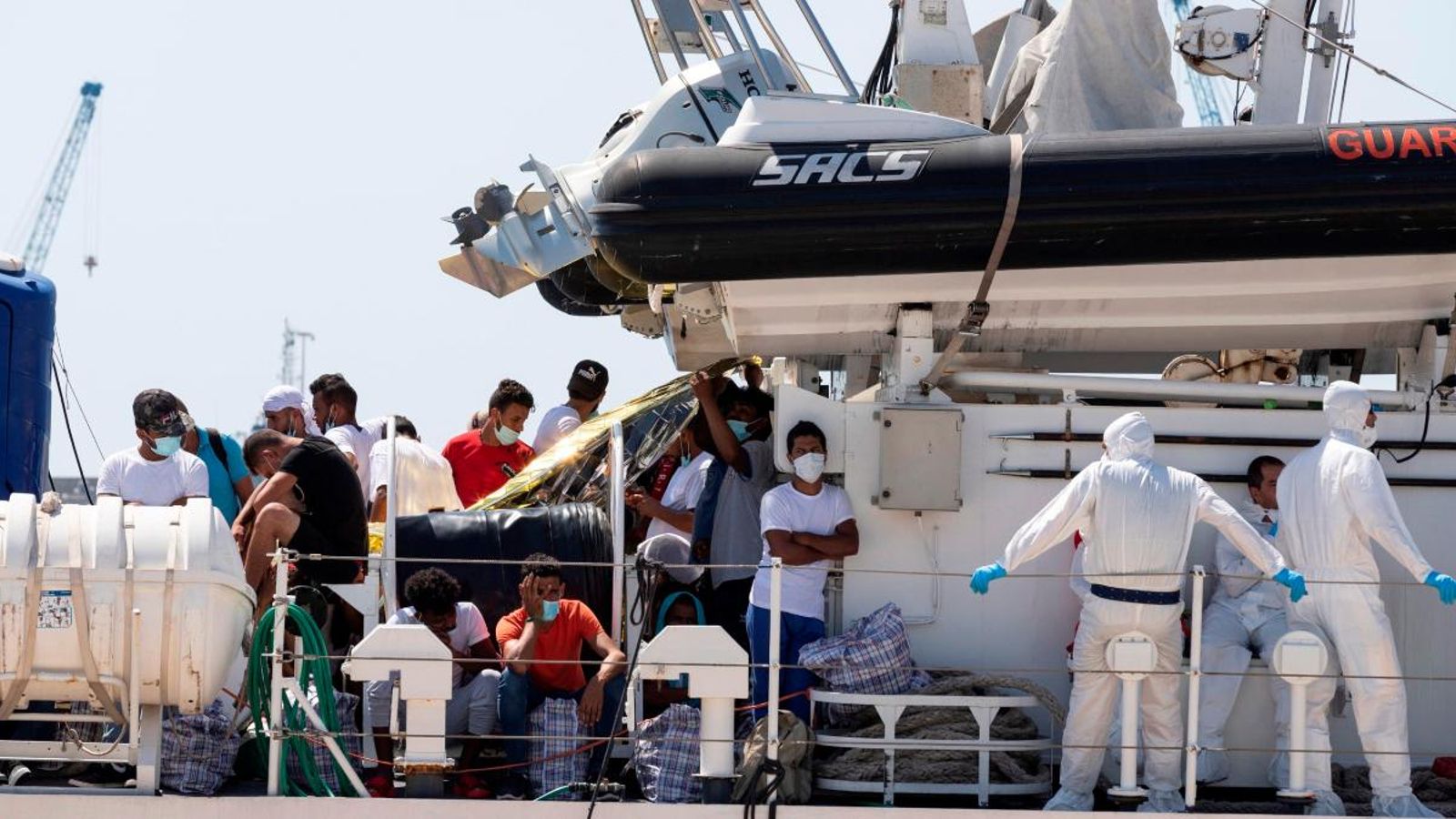 Migrants arribats a Lampedusa en el moment de desembarcar a Pozzallo després de ser traslladats