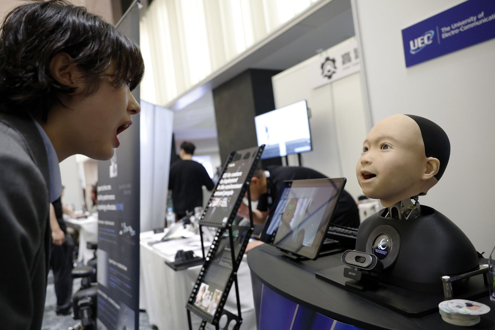 Un jove interactua amb un robot humanoide en l’estand d’Avita durant el ‘Humanoids Summit’ a Tòquio, al Japó