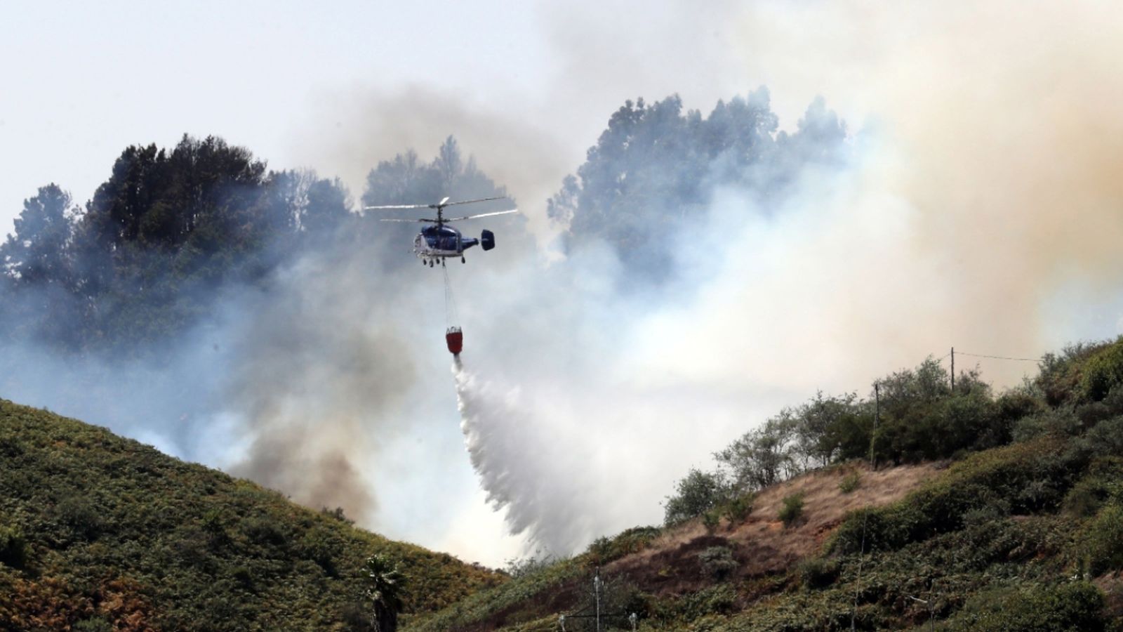 Un helicòpter treballa en les tasquesd'extinció de l'incendi forestal a Gran Canària