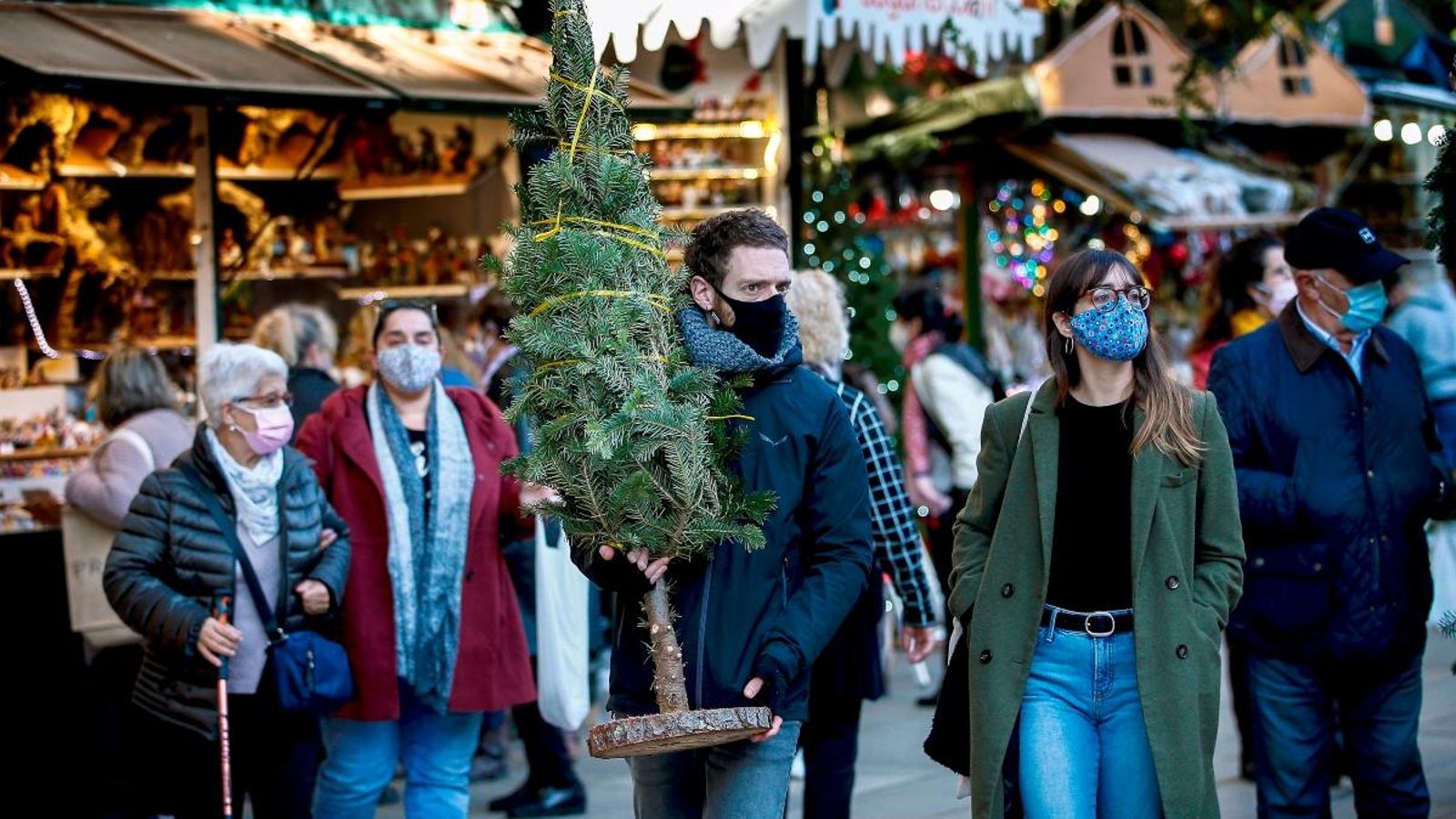Els clients passegen aquest dilluns per la Fira de Santa Llúcia, a Barcelona, on el risc de rebrot continua baixant