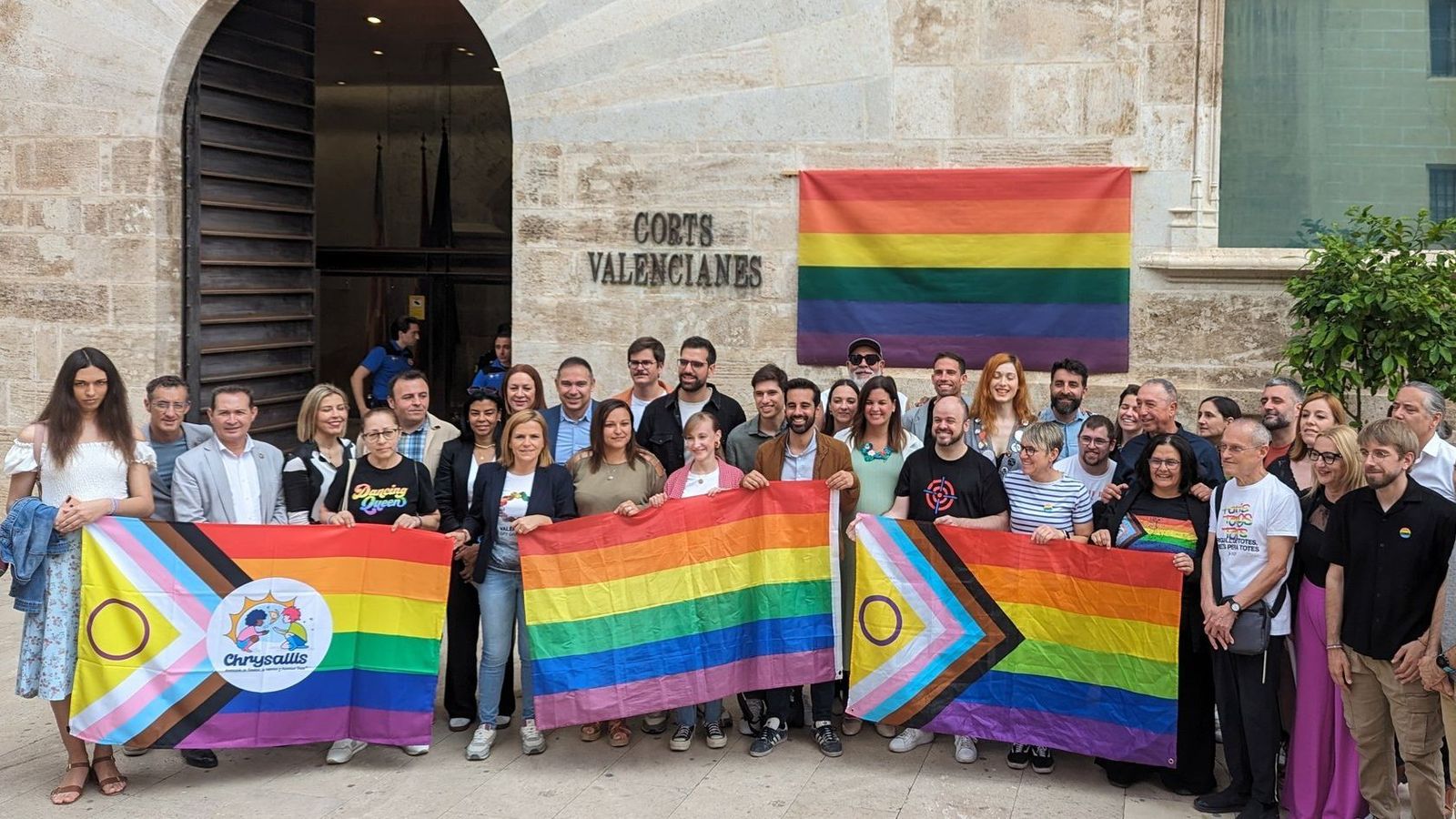 Representants del Pspv i Compromís, amb els d'entitats del col·lectiu LGTBI, en l'acte alternatiu que han convocat a les portes de les Corts