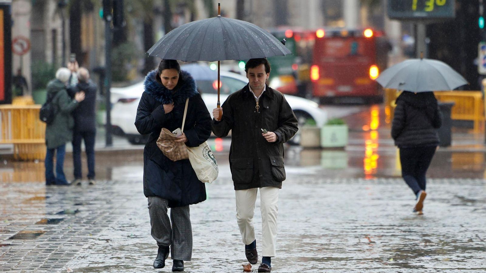 Diverses persones es cobreixen amb un paraigua en un carrer de València