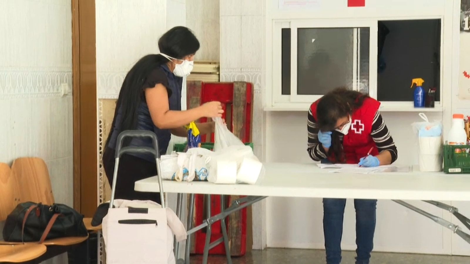 Una voluntària de la Creu Roja atén a una usuària