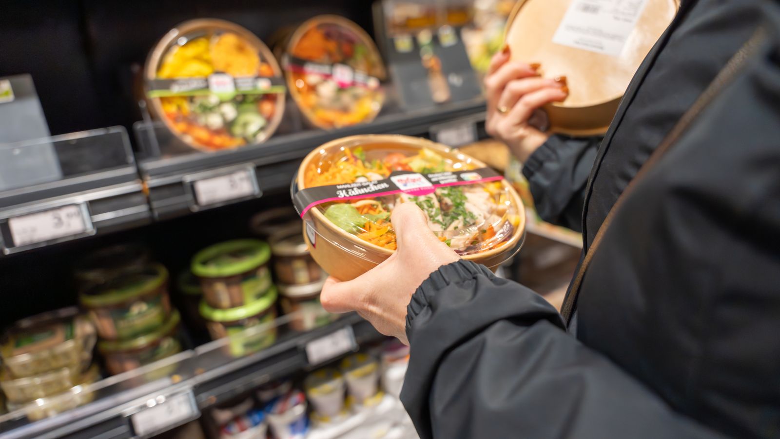 Una consumidora en un aparador de menjar preparat