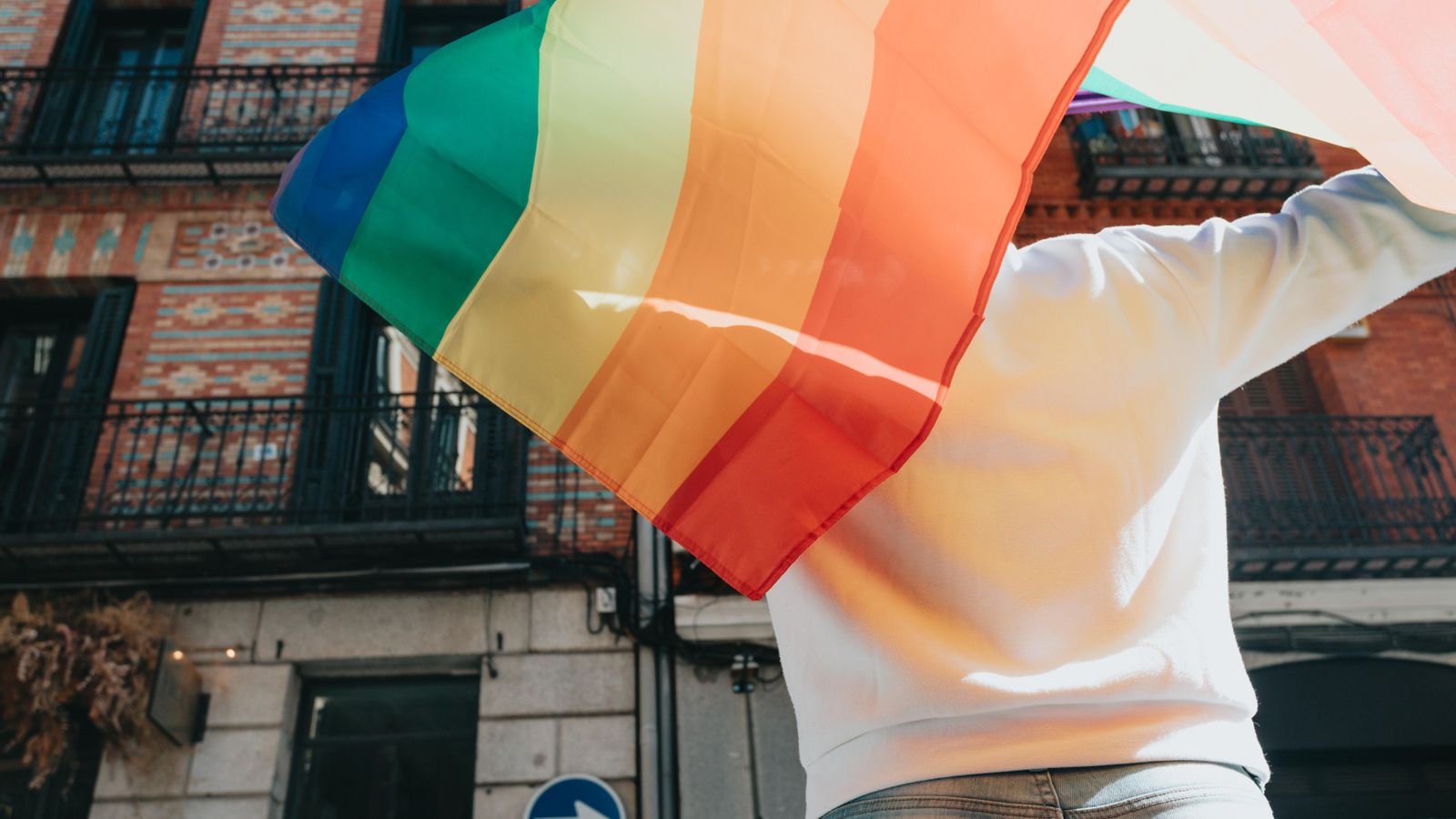 Una persona amb la bandera multicolor emblema del colectiu LGTBI