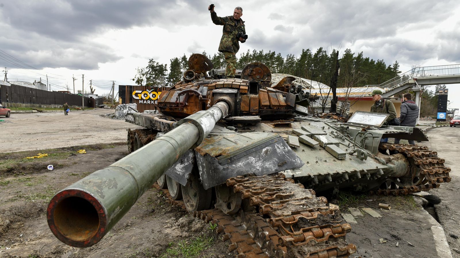 Un home puja a un tanc rus destruït en l'àrea de Kíev