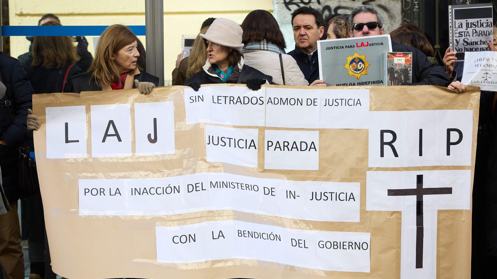 Diversos lletrats es concentren amb cartells i una pancarta mentre té lloc una reunió del comité de vaga amb Justícia