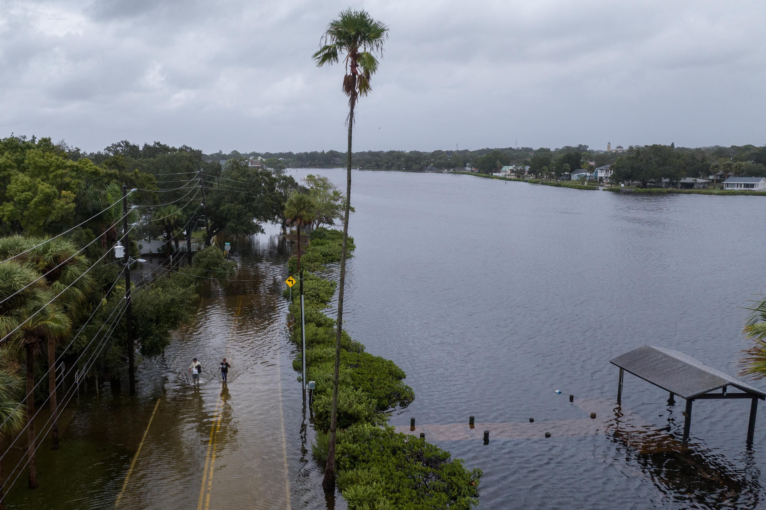 Residents caminen per un carrer inundat a Tarpon Springs Residents caminen per un carrer inundat a Tarpon Springs