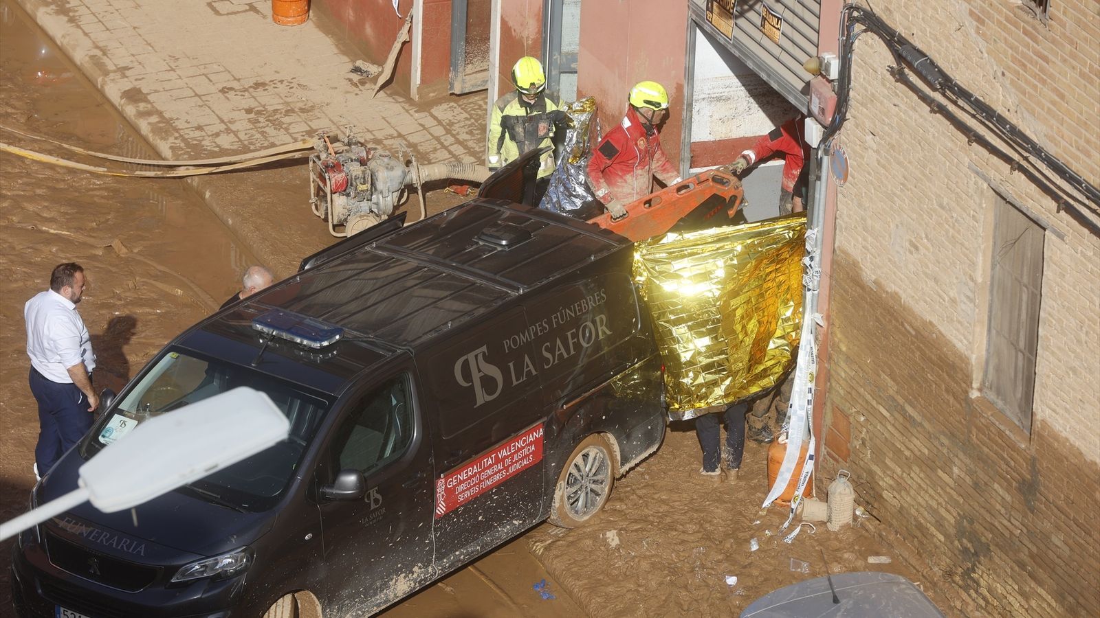 Un furgó de la funerària recull d'un garatge cadàvers localitzats al barri de la Torre