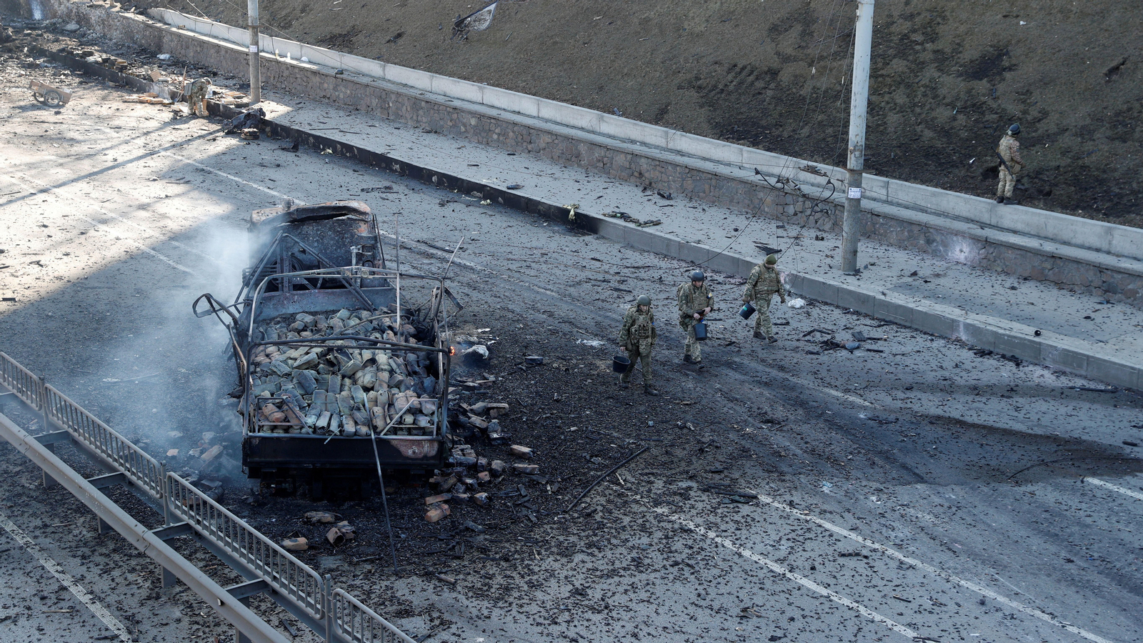 Soldats ucraïnesos caminen al costat d'un vehicle atacat per unitats russes