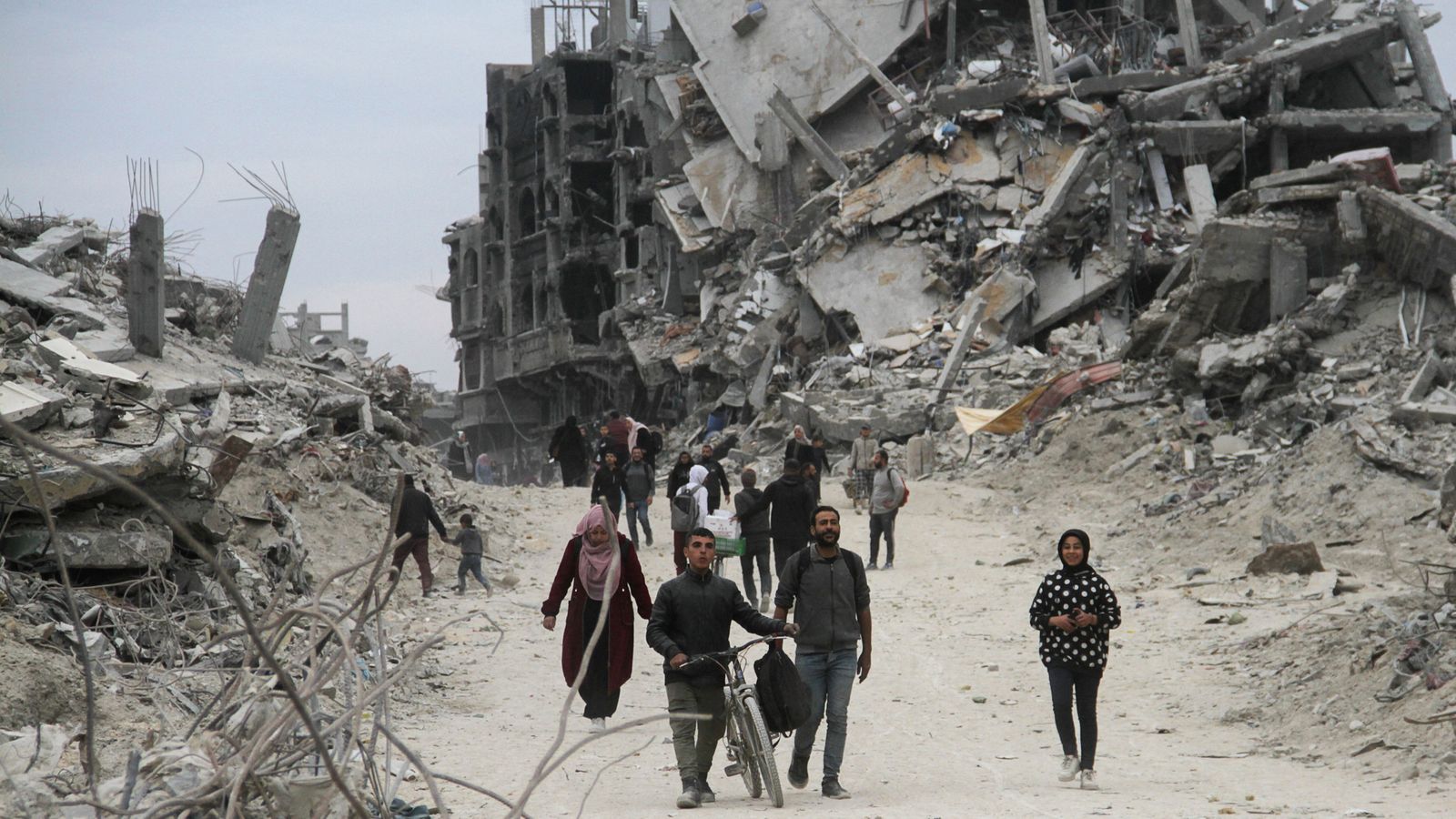 Un grup de palestins camina al campament de Jabalia, que l'ofensiva isrealiana ha reduït a enderrocs