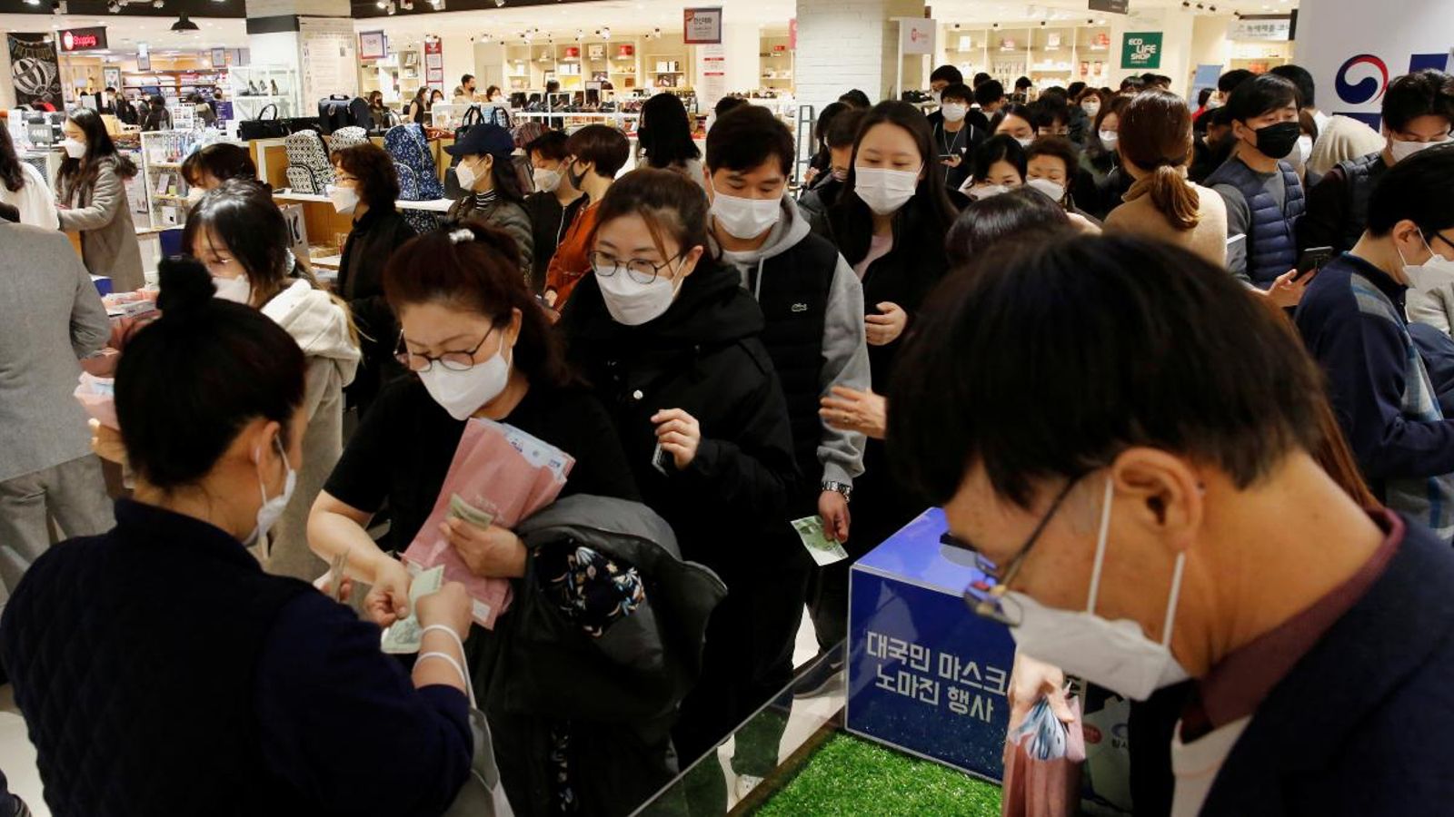 Diverses persones fan cua per a comprar mascaretes