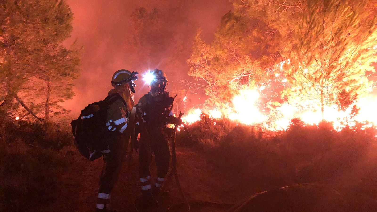 Bombers treballant de matinada en l'incendi forestal