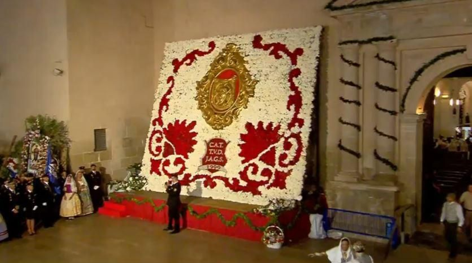 Imatge del tapís on es poden veure les inicials dels tres foguerers a què s'ha volgut retre homenatge