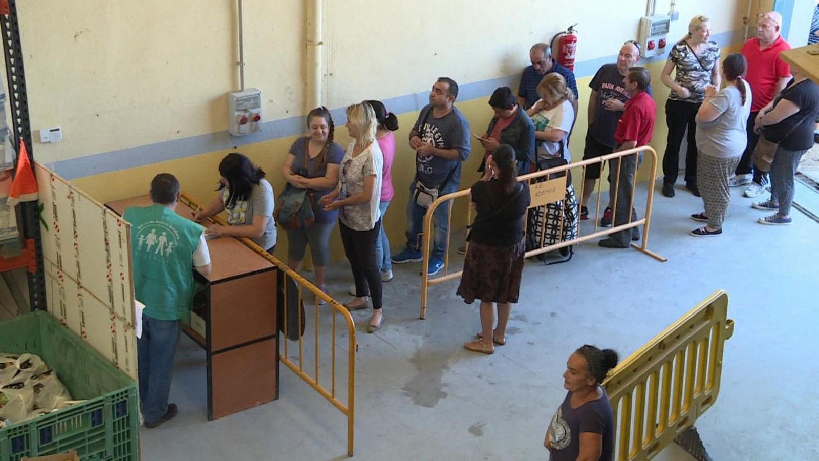 Persones fan cua per a rebre ajudes per a menjar a Càritas
