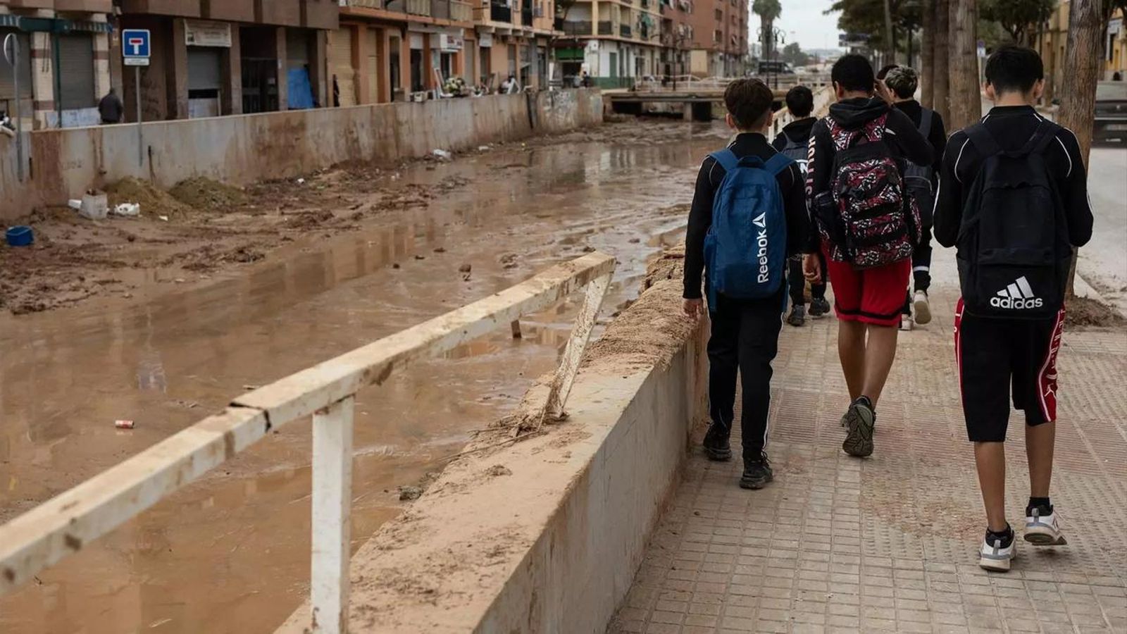 Diversos estudiants, al costat dels estralls de la dana a Aldaia, després d'eixir d'escola