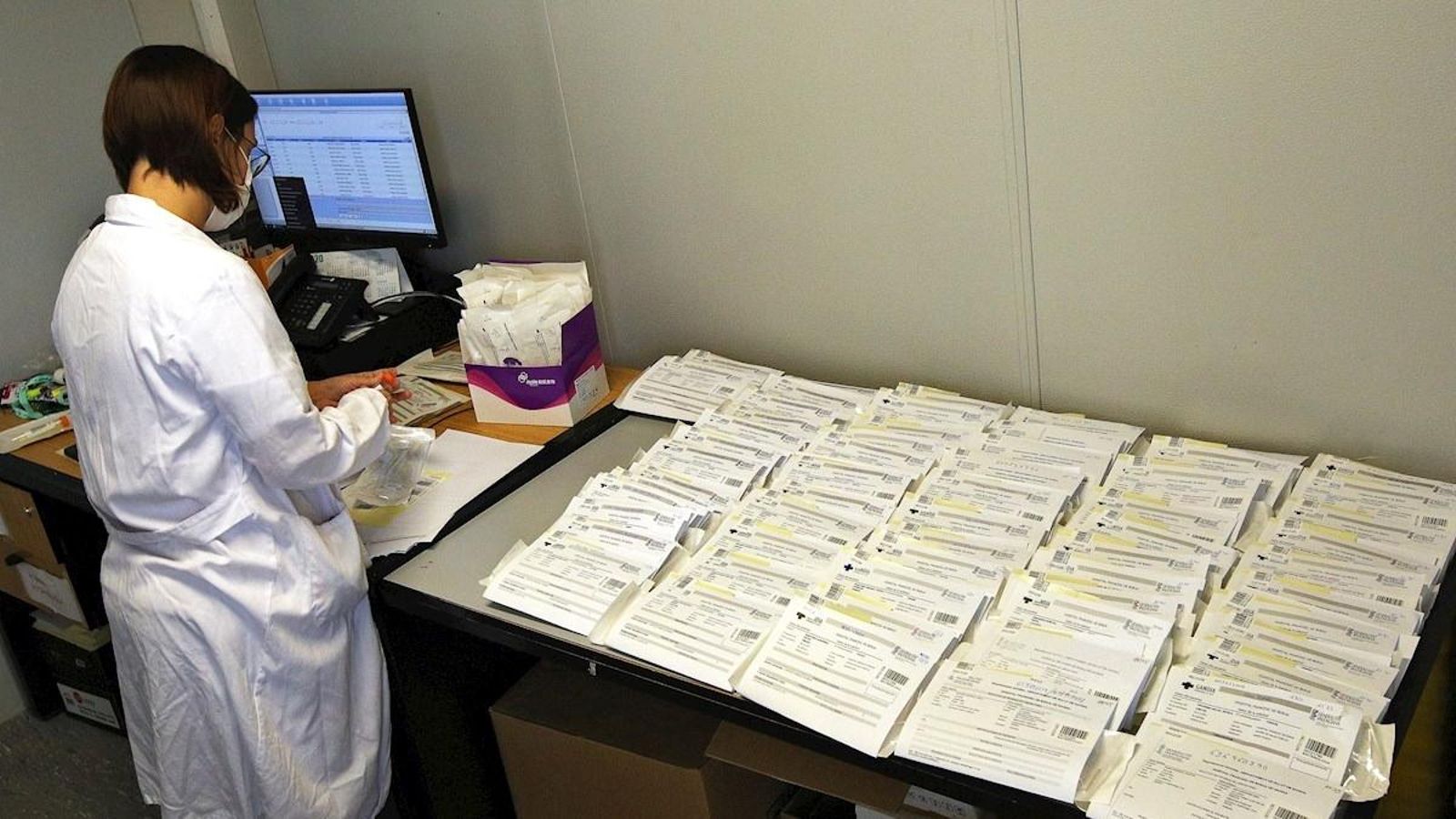 En la imatge una sanitària processa  desenes de mostres per a prova PCR a l'hospital de Gandia