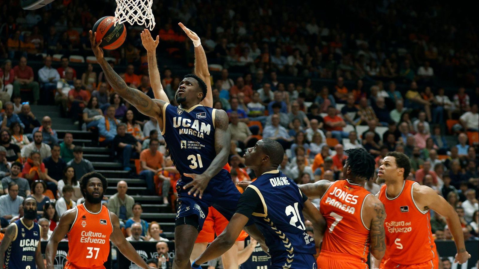 La defensa taronja tracta d'evitar una cistella d'Ennis