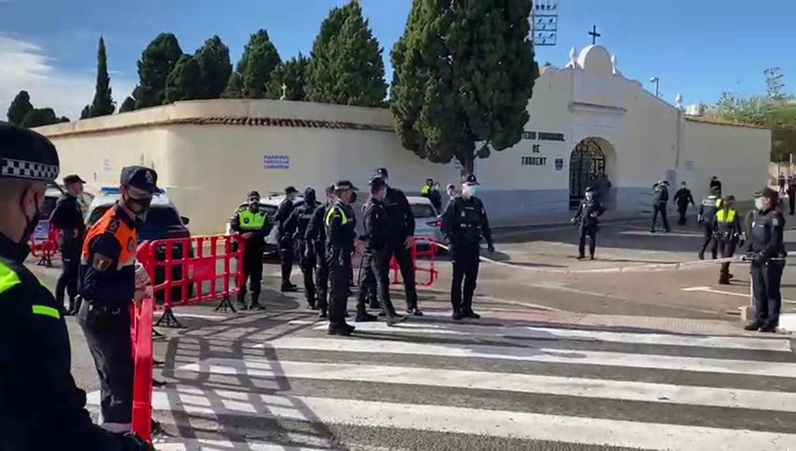 Agents de la Policia Local i Protecció Civil despleguen tanques per a impedir l'accés al cementeri de Torrent