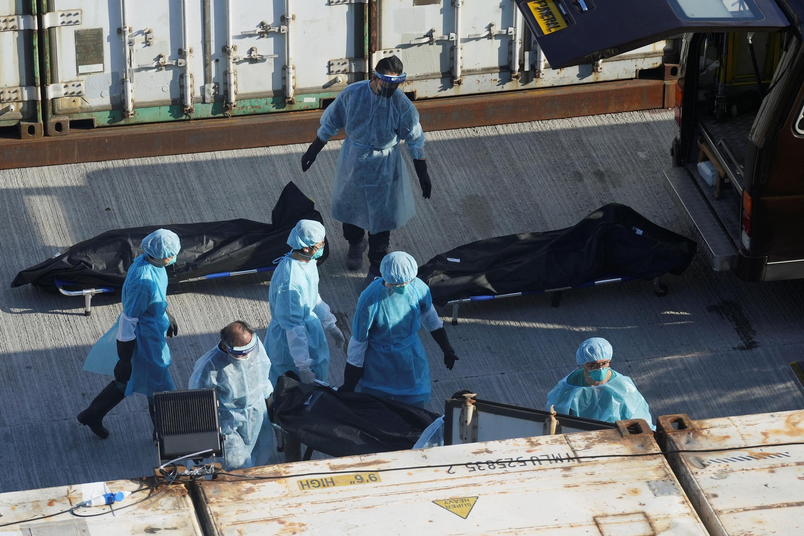Un grup de treballadors sanitaris de Hong Kong trasllada els cadàvers de pacients de covid a un mortuori Un grup de treballadors sanitaris de Hong Kong trasllada els cadàvers de pacients de covid a un mortuori