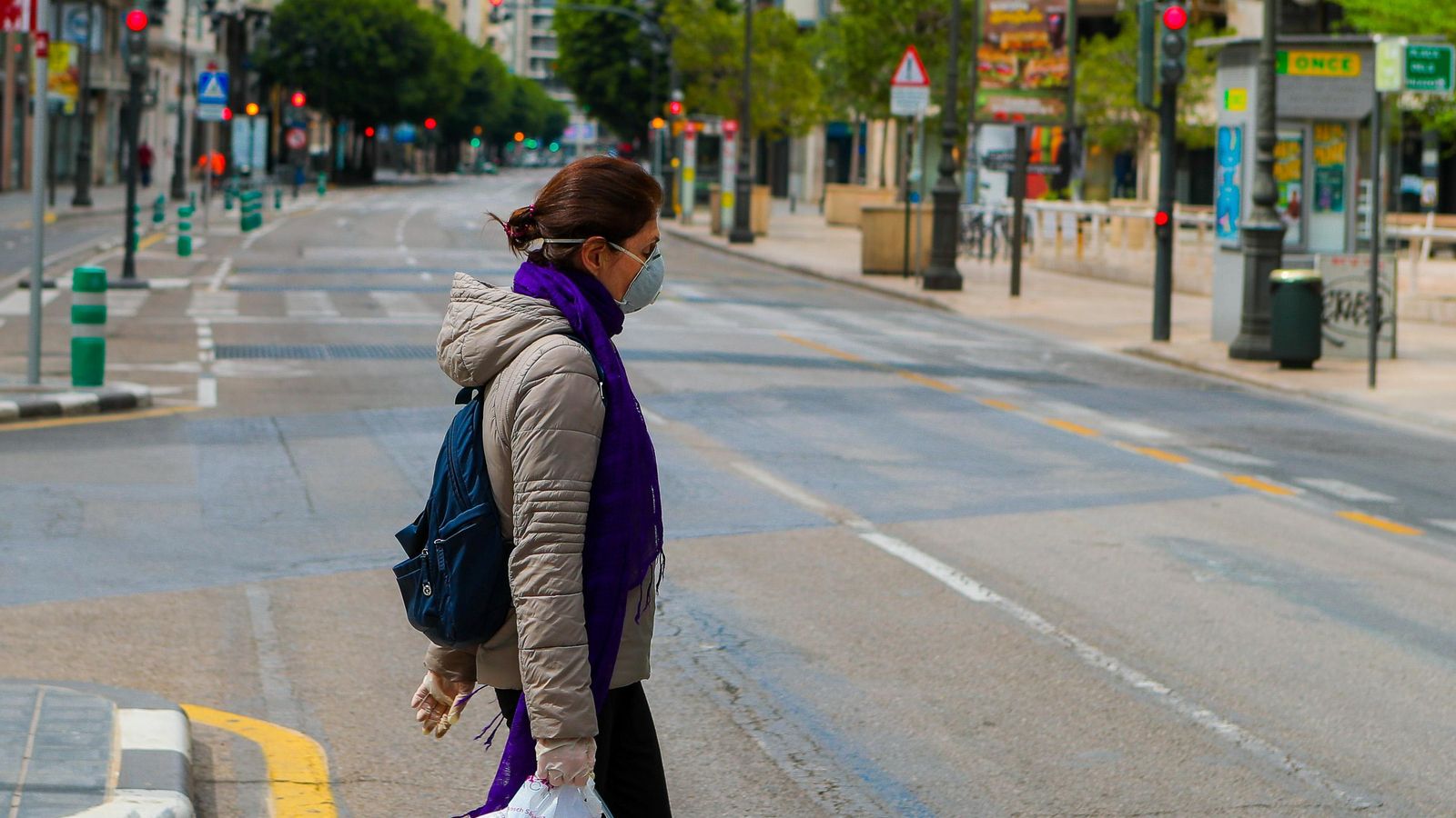 Imatge d'una dona creuant un carrer del centre de València durant l'estat d'alarma
