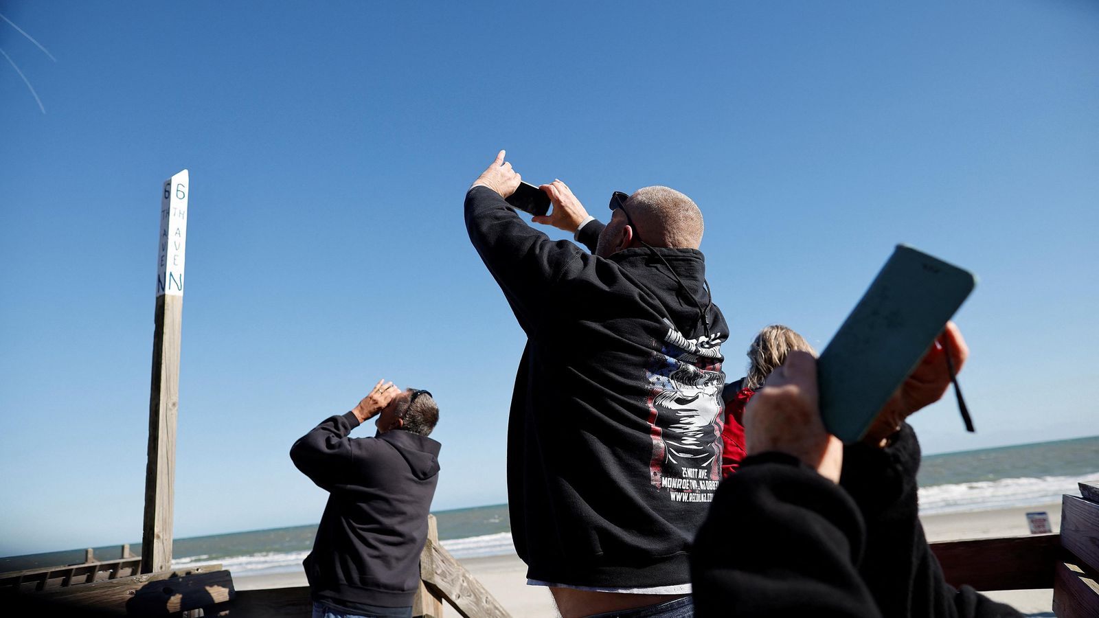 Un grup de persones fotografia el globus xinés enfront de la costa a Surfside Beach a Texas