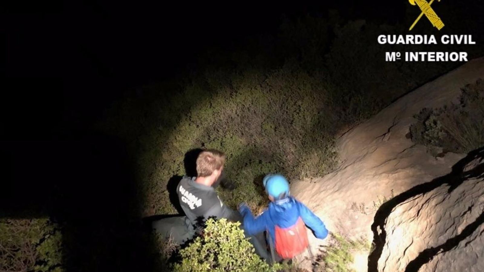 Un guàrdia civil ajuda un dels xiquets en el descens