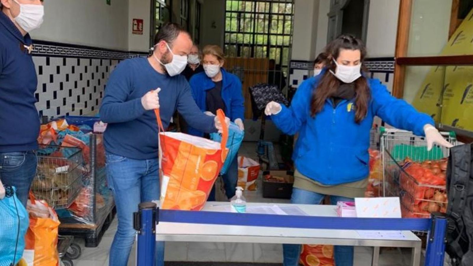 Personal de Casa Caritat fent un repartiment de productes alimentaris durant l'estat d'alarma