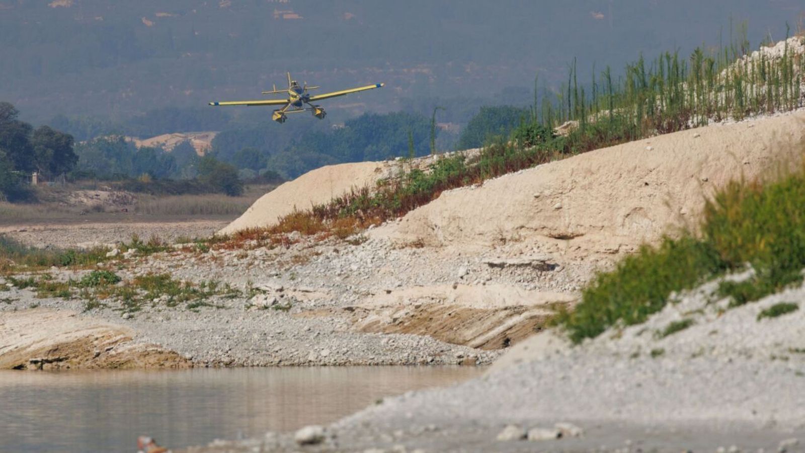 Un mitjà aeri del dispositiu de l'incendi de Benasau sobrevola el pantà de Beniarrés, dimecres