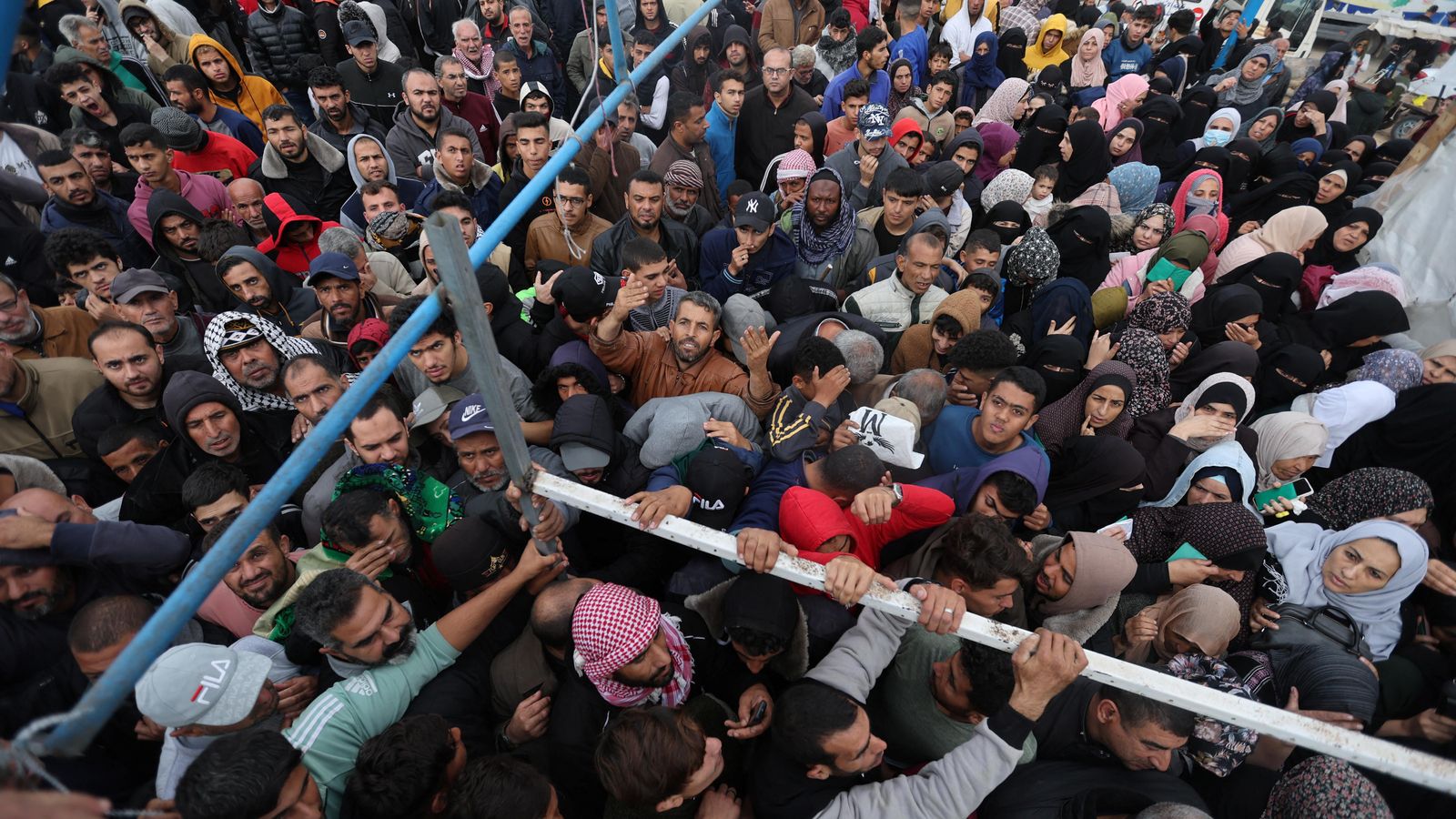 Un grup de palestins a l'espera de l'entrega d'ajuda humanitària