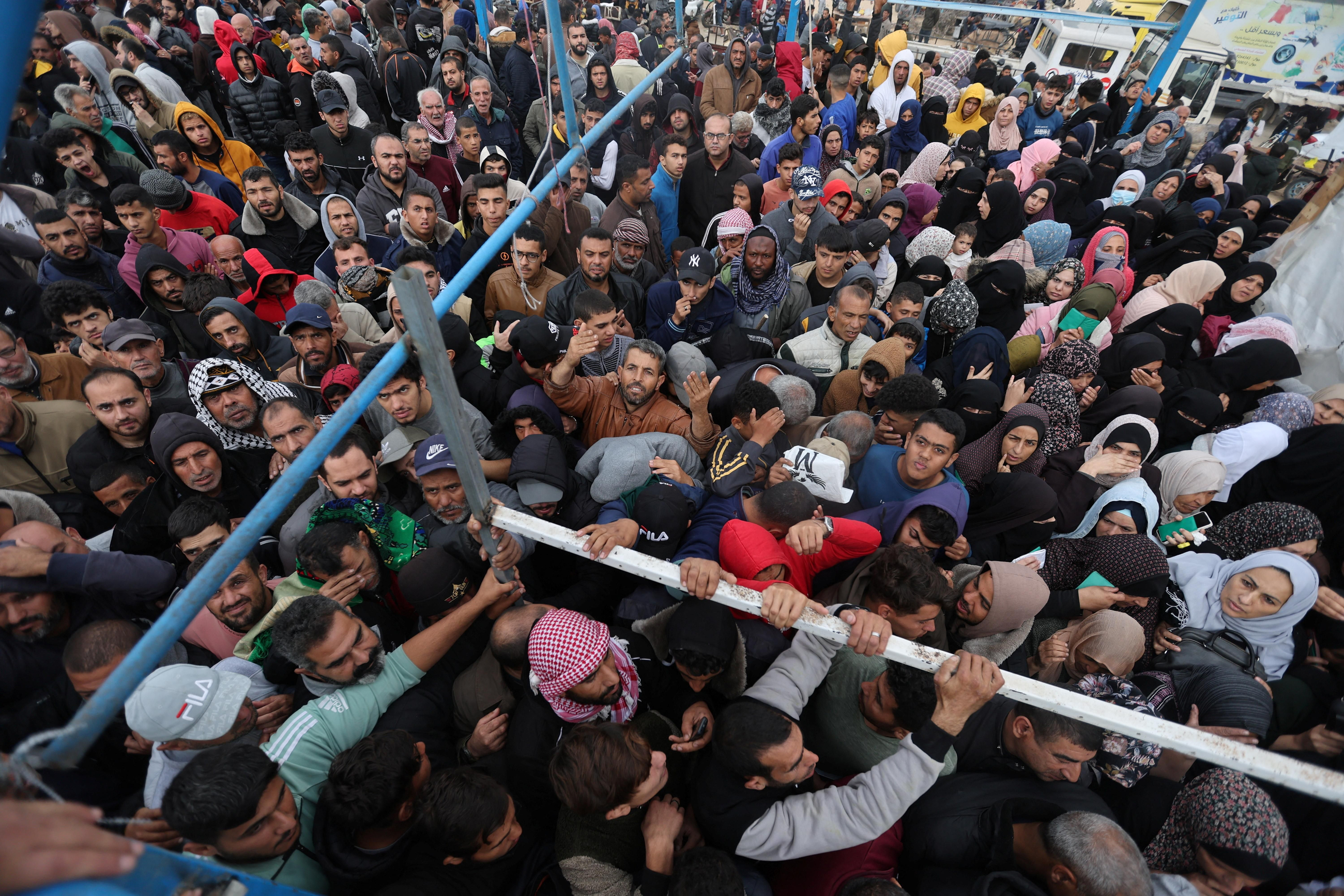 Un grup de palestins a l'espera de l'entrega d'ajuda humanitària Un grup de palestins a l'espera de l'entrega d'ajuda humanitària