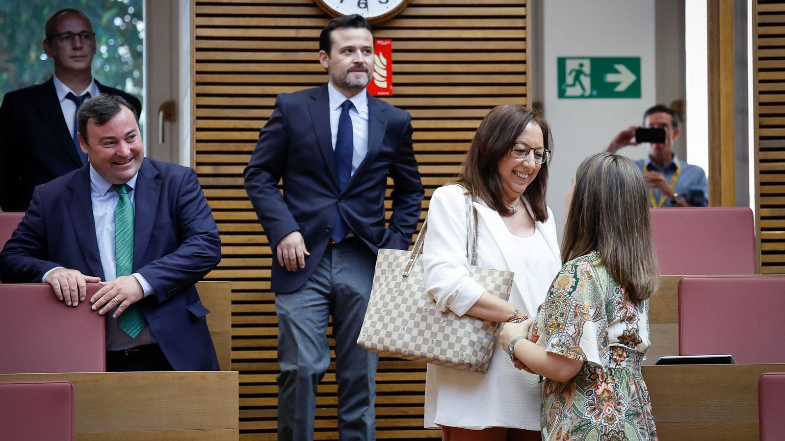 Llanos Massó, nova presidenta de les Corts, saluda una altra parlamentària en arribar a l'hemicicle