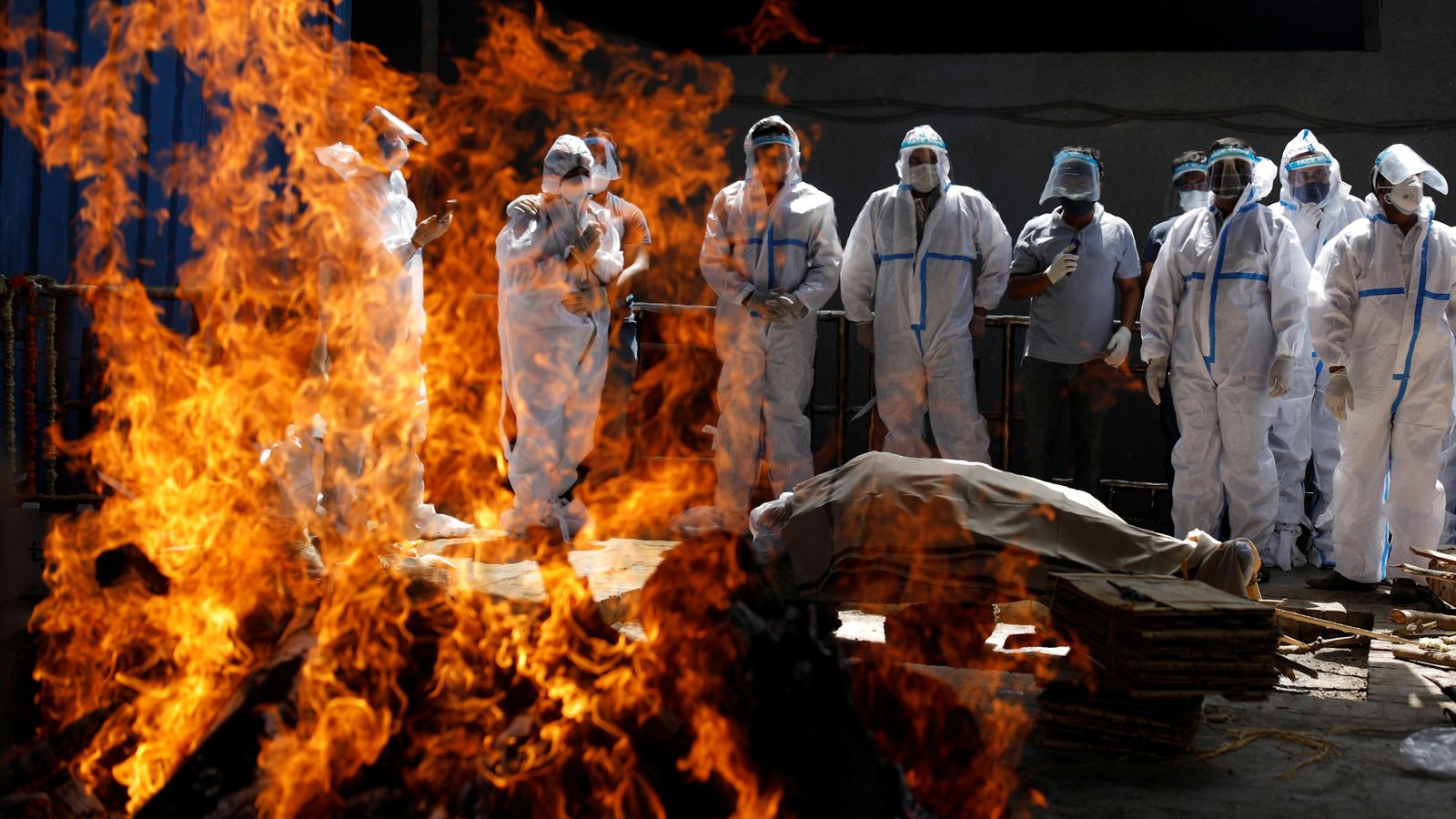 Familiars amb equips de protecció assisteixen al funeral d'un home, que va morir a causa del coronavirus en un crematori a Nova Delhi, l'Índia