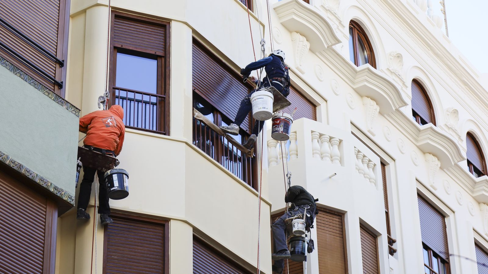 Diversos operaris treballen en la façana d'un edifici a Alacant
